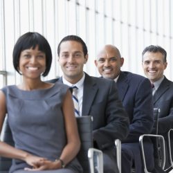 Smiling business people sitting in a line